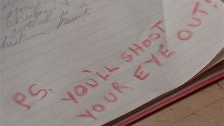 Note paper with  "p.s. You'll shoot your eye out!" written in red pencil