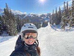 A skier on a run with the mountains in the background