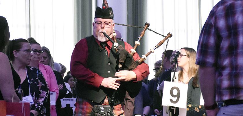 A bagpiper walks into the assembly kicking off this year's ARA