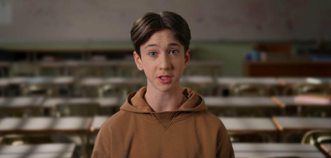 Male student in brown hoodie speaking to the camera